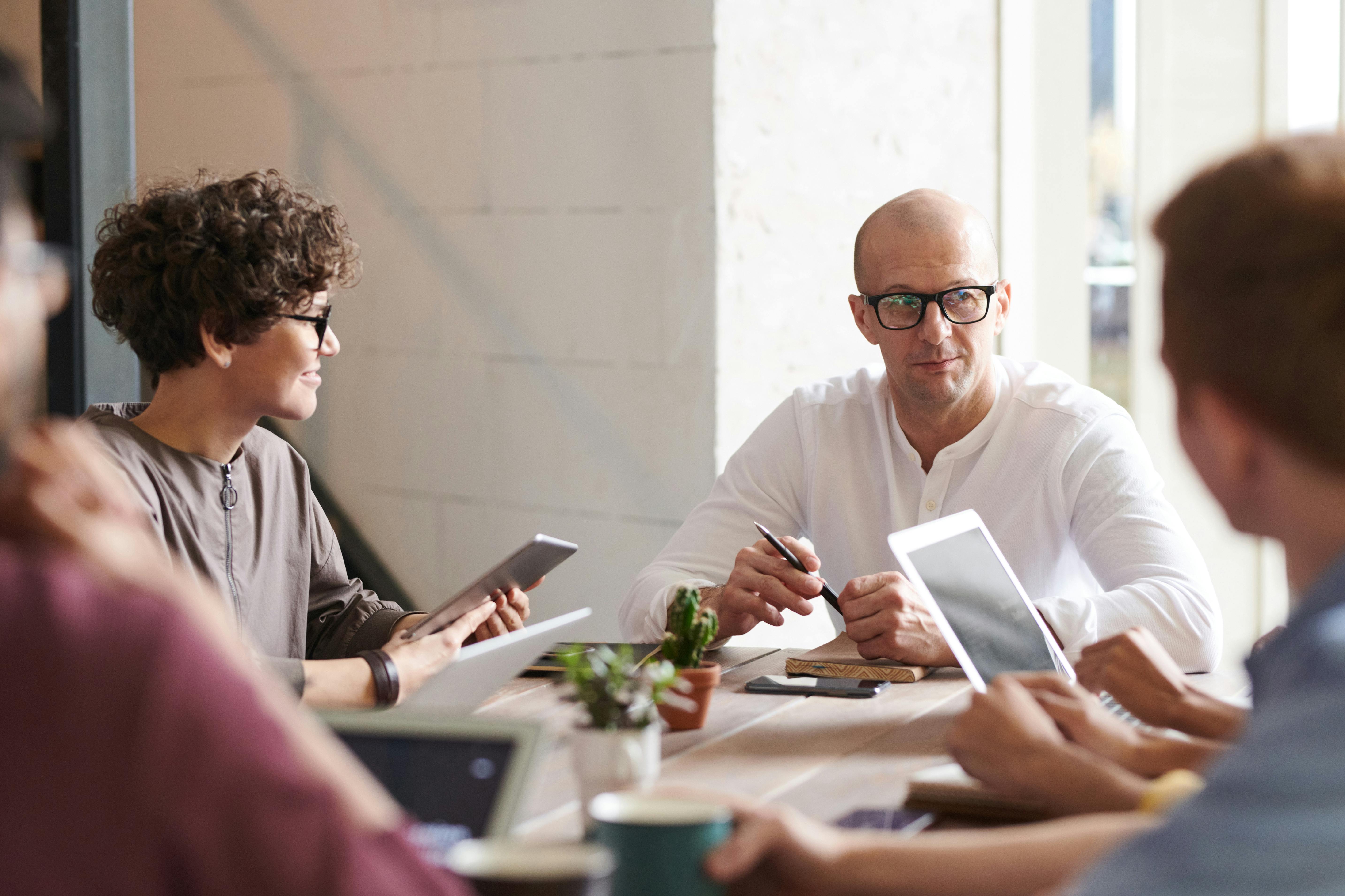 Four people engaged in a calm, supportive conversation over coffee in a cozy setting, representing understanding and empathetic guidance for life insurance with mental health considerations.