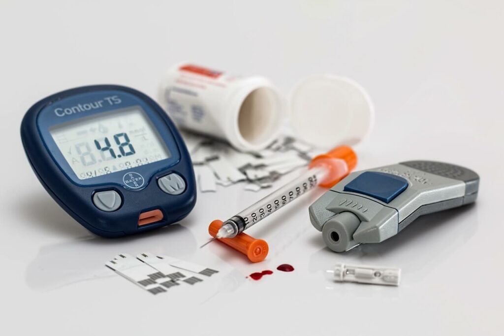 Diabetes management tools for tracking A1C, including insulin injector, test strips, and pill bottle—important for diabetics with neuropathy applying for life insurance.